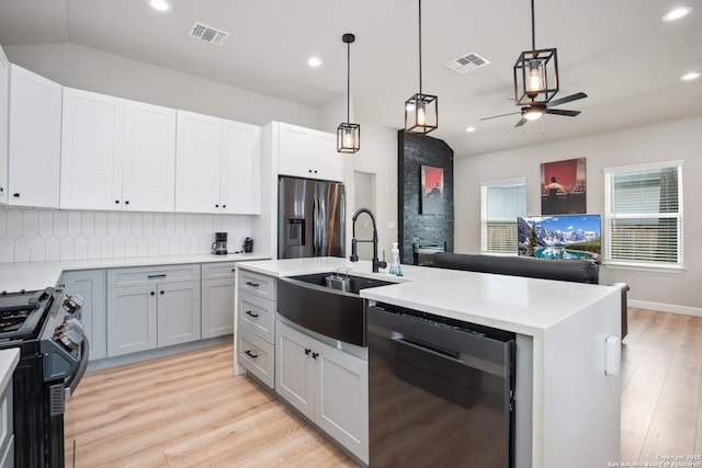 239 Porter, San Antonio, TX 78210 - kitchen featuring appliances with stainless steel finishes, a sink, ceiling fan, tasteful backsplash, and light wood-style floors