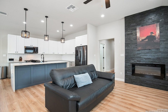 239 Porter, San Antonio, TX 78210 - living room featuring ceiling fan, light wood-style flooring, a fireplace, and recessed lighting