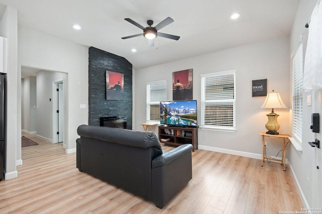 239 Porter, San Antonio, TX 78210 - living room with a fireplace, light wood-style floors, vaulted ceiling, a ceiling fan, and plenty of natural light