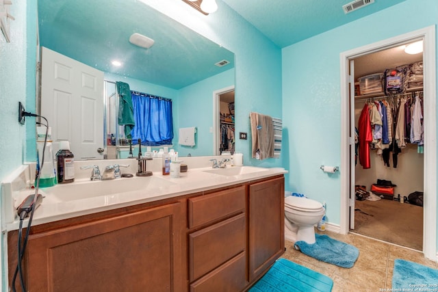 8514 Bayliss Pt, San Antonio, TX 78252 - full bathroom with double vanity, a walk in closet, toilet, and tile patterned flooring