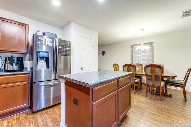 8514 Bayliss Pt, San Antonio, TX 78252 - kitchen featuring stainless steel refrigerator with ice dispenser, light wood finished floors, a chandelier, dark countertops, and recessed lighting