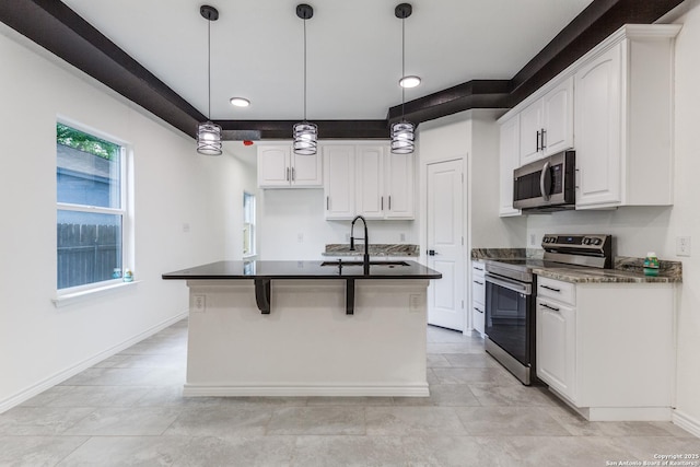 623 Recio St, San Antonio, TX 78225 - kitchen featuring appliances with stainless steel finishes, dark countertops, a sink, white cabinets, and an island with sink