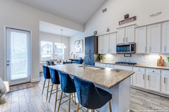 28806 Oldlyme, San Antonio, TX 78260 - kitchen with a sink, stainless steel microwave, gas stovetop, high vaulted ceiling, and decorative backsplash