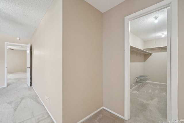 10222 Eagle Blf, San Antonio, TX 78249 - hallway featuring a textured ceiling, carpet floors, and baseboards
