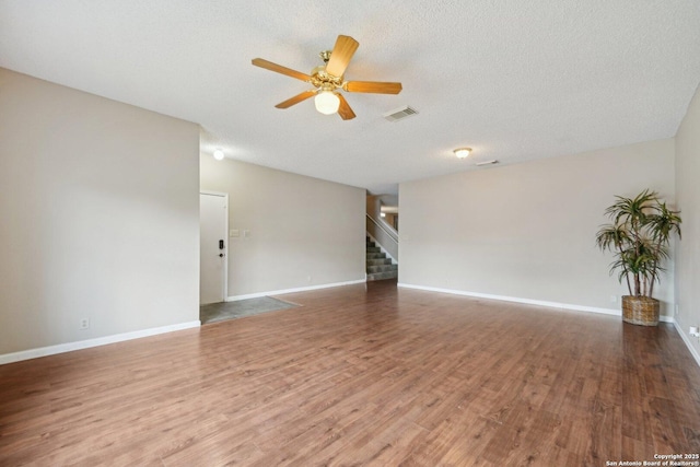 10222 Eagle Blf, San Antonio, TX 78249 - unfurnished living room with stairs, ceiling fan, a textured ceiling, wood finished floors, and baseboards