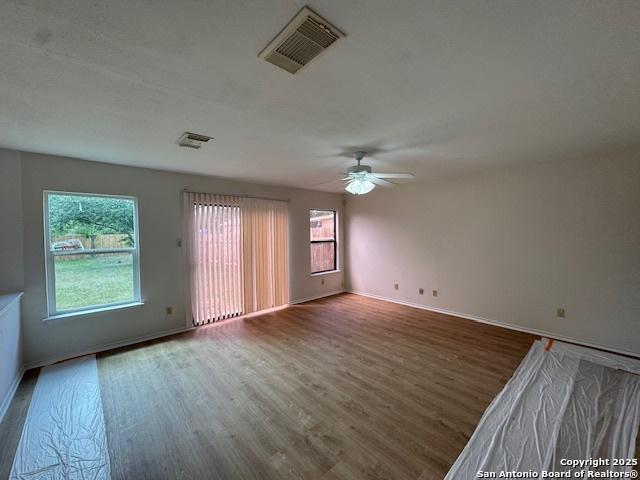 7011 Cole Crk, Converse, TX 78109 - unfurnished room with wood finished floors, healthy amount of natural light, and ceiling fan