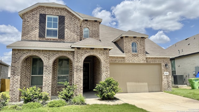 10828 Bango Farms, San Antonio, TX 78254 - french country style house featuring brick siding, driveway, a garage, central air condition unit, and a shingled roof