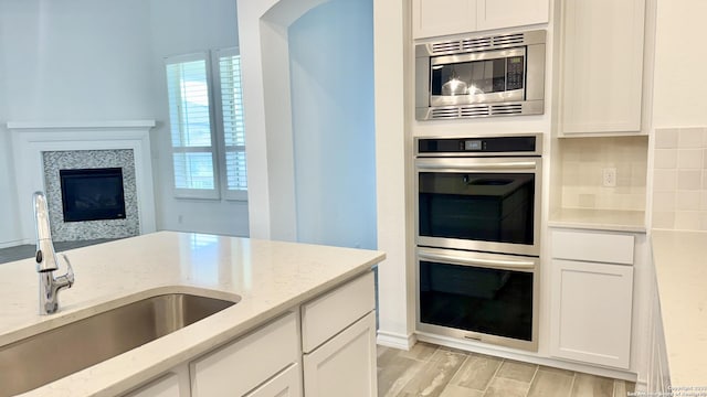10828 Bango Farms, San Antonio, TX 78254 - kitchen with appliances with stainless steel finishes, a sink, white cabinets, and light stone counters