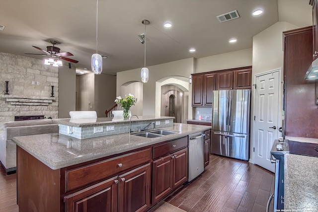 1009 Oak Rdg, Schertz, TX 78154 - kitchen with appliances with stainless steel finishes, a sink, arched walkways, a center island with sink, and dark wood finished floors
