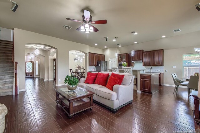 1009 Oak Rdg, Schertz, TX 78154 - living area with ceiling fan, stairs, baseboards, arched walkways, and dark wood-style flooring