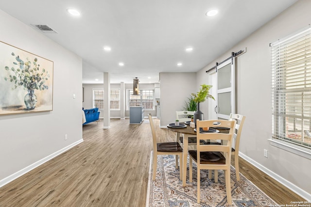 371 Pike, San Antonio, TX 78209 - dining area with a barn door, wood finished floors, recessed lighting, and baseboards