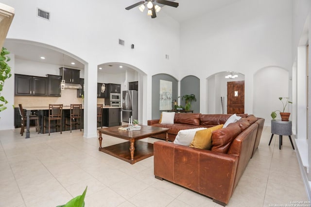 22450 Viajes, San Antonio, TX 78261 - living room with a ceiling fan, a high ceiling, arched walkways, and light tile patterned flooring
