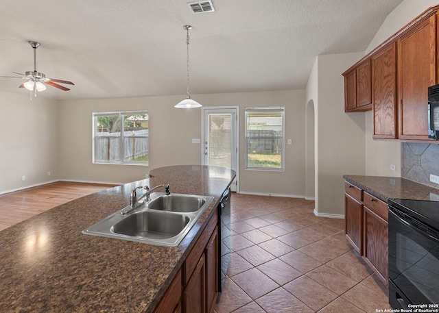7319 Tranquillo Way, San Antonio, TX 78266 - kitchen featuring black appliances, a sink, dark countertops, a ceiling fan, and arched walkways