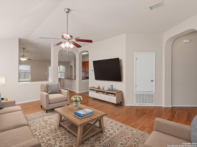 7319 Tranquillo Way, San Antonio, TX 78266 - living room featuring arched walkways, a ceiling fan, wood finished floors, baseboards, and vaulted ceiling
