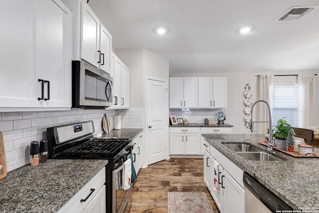 29416 Autumn Copper, Bulverde, TX 78163 - kitchen with stainless steel appliances, a sink, wood finished floors, dark stone countertops, and white cabinetry