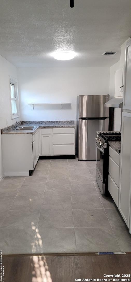 359 Revlon, San Antonio, TX 78227 - kitchen with range with gas cooktop, freestanding refrigerator, a sink, white cabinets, and under cabinet range hood