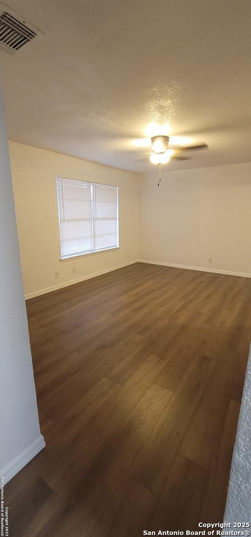 359 Revlon, San Antonio, TX 78227 - spare room featuring dark wood-style flooring, baseboards, and ceiling fan
