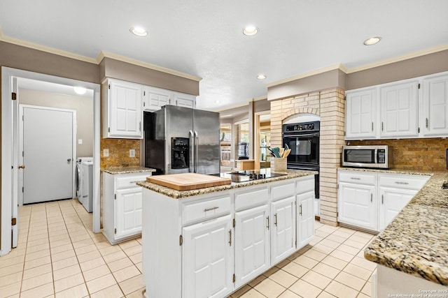 2002 Encino Vly, San Antonio, TX 78259 - kitchen with black appliances, washer and dryer, light tile patterned floors, recessed lighting, and a center island