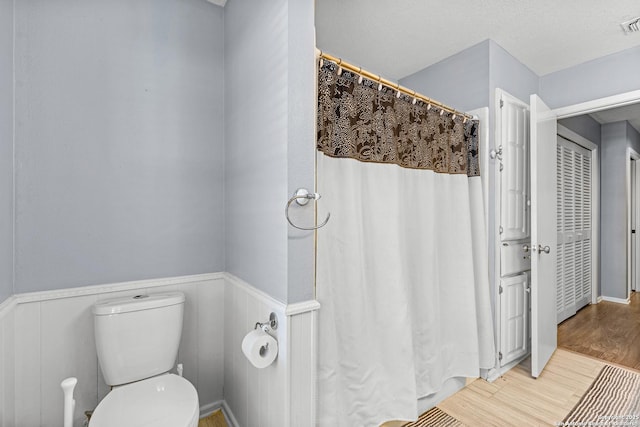 2002 Encino Vly, San Antonio, TX 78259 - full bathroom with wainscoting, toilet, wood finished floors, and a shower with curtain