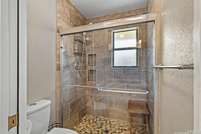 2002 Encino Vly, San Antonio, TX 78259 - bathroom with toilet, a textured wall, and a stall shower