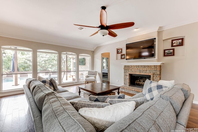 6502 Amber Oak, San Antonio, TX 78249 - living area with ceiling fan, plenty of natural light, ornamental molding, wood finished floors, and a brick fireplace