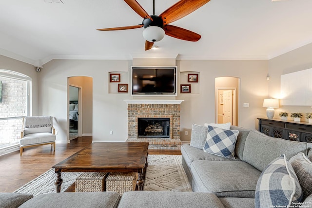6502 Amber Oak, San Antonio, TX 78249 - living room with arched walkways, ceiling fan, wood finished floors, ornamental molding, and a fireplace