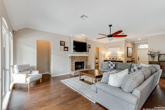 6502 Amber Oak, San Antonio, TX 78249 - living area featuring ornamental molding, ceiling fan, baseboards, a brick fireplace, and dark wood-style floors