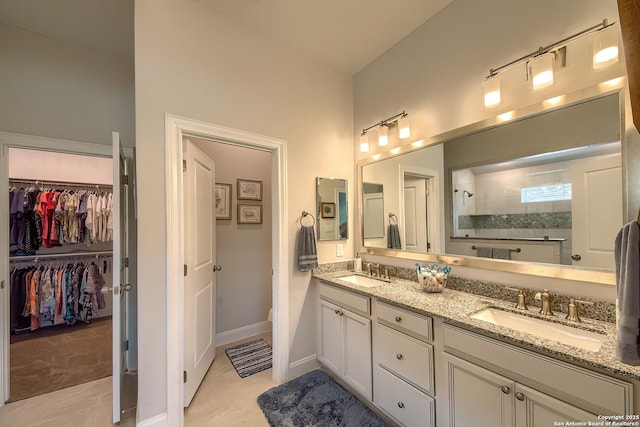 14815 Highdere, San Antonio, TX 78245 - full bathroom with double vanity, walk in shower, a walk in closet, toilet, and baseboards