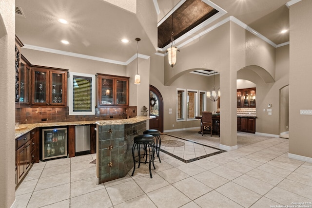 208 Cascade Caverns, Boerne, TX 78015 - indoor wet bar featuring arched walkways, wine cooler, decorative backsplash, light tile patterned floors, and recessed lighting