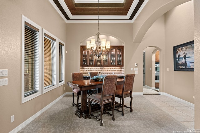 208 Cascade Caverns, Boerne, TX 78015 - dining space with a chandelier, arched walkways, ornamental molding, a tray ceiling, and baseboards