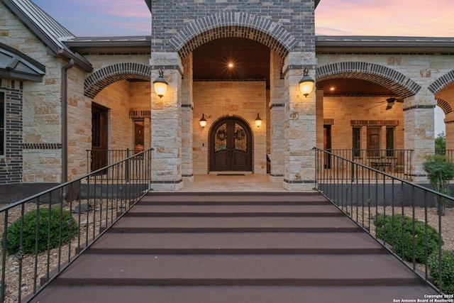 208 Cascade Caverns, Boerne, TX 78015 - exterior entry at dusk with stone siding and a porch