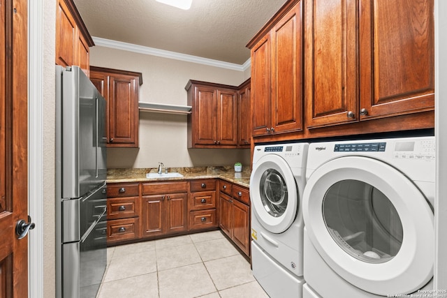 208 Cascade Caverns, Boerne, TX 78015 - laundry area featuring crown molding, washing machine and dryer, a textured ceiling, cabinet space, and light tile patterned floors
