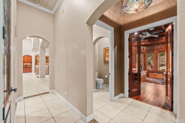 208 Cascade Caverns, Boerne, TX 78015 - foyer with crown molding, arched walkways, light tile patterned floors, a textured wall, and baseboards