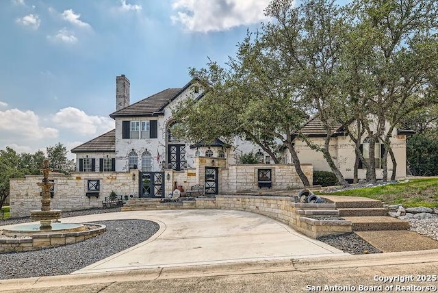 41 Champions Run, San Antonio, TX 78258 - view of front facade featuring stone siding, a chimney, and stucco siding
