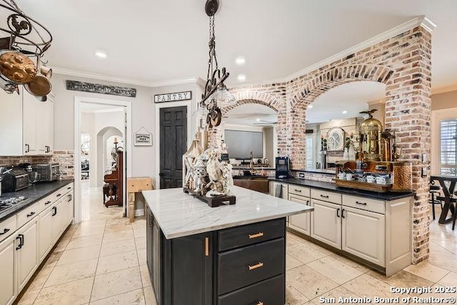 41 Champions Run, San Antonio, TX 78258 - kitchen with arched walkways, decorative columns, ornamental molding, a kitchen island, and backsplash