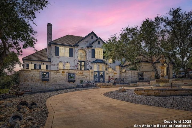 41 Champions Run, San Antonio, TX 78258 - view of front facade with stone siding and a chimney