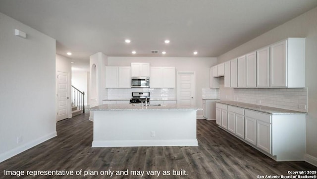 21055 Millstream Bnd, San Antonio, TX 78266 - kitchen featuring appliances with stainless steel finishes, recessed lighting, white cabinets, tasteful backsplash, and a kitchen island with sink