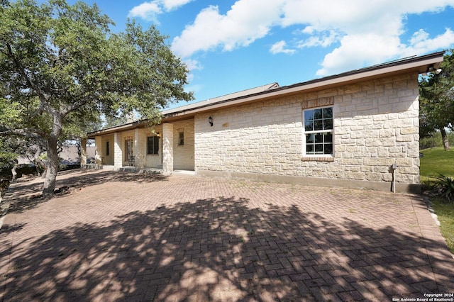 25927 Echo Mtn, San Antonio, TX 78260 - rear view of house featuring stone siding and a patio area