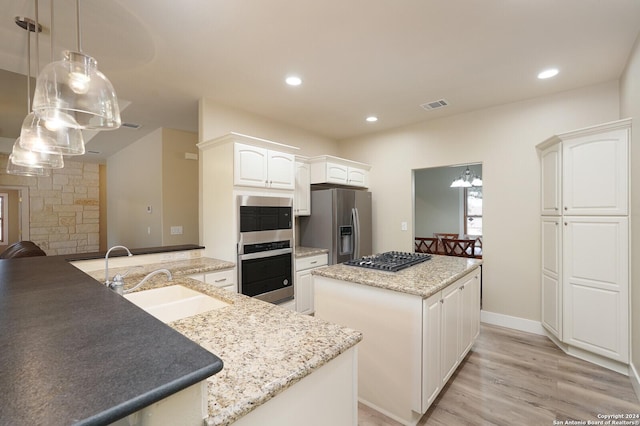 25927 Echo Mtn, San Antonio, TX 78260 - kitchen with a sink, appliances with stainless steel finishes, a kitchen island, light wood finished floors, and decorative light fixtures