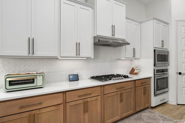1817 Delafield, San Antonio, TX 78253 - kitchen with stainless steel appliances, under cabinet range hood, light countertops, and tasteful backsplash