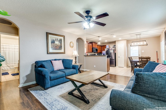11334 Luckey Ledge, San Antonio, TX 78252 - living room with arched walkways, light wood-style floors, ceiling fan, baseboards, and recessed lighting