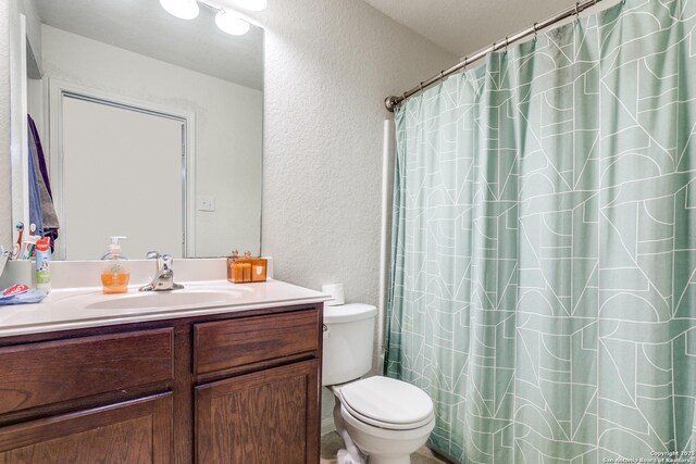 11334 Luckey Ledge, San Antonio, TX 78252 - bathroom with a textured wall, vanity, toilet, and curtained shower