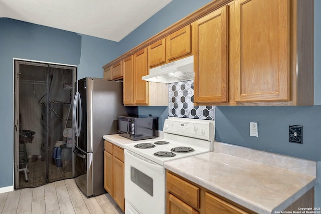 8810 Pensive, Converse, TX 78109 - kitchen featuring white range with electric stovetop, under cabinet range hood, black microwave, freestanding refrigerator, and light countertops