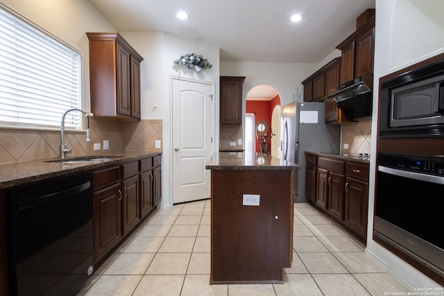 8219 Wayside Crk, San Antonio, TX 78255 - kitchen with black appliances, a sink, a center island, arched walkways, and backsplash