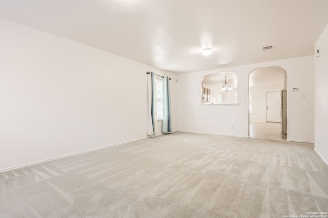 9215 Granberry, Universal City, TX 78148 - spare room featuring arched walkways, light colored carpet, and baseboards