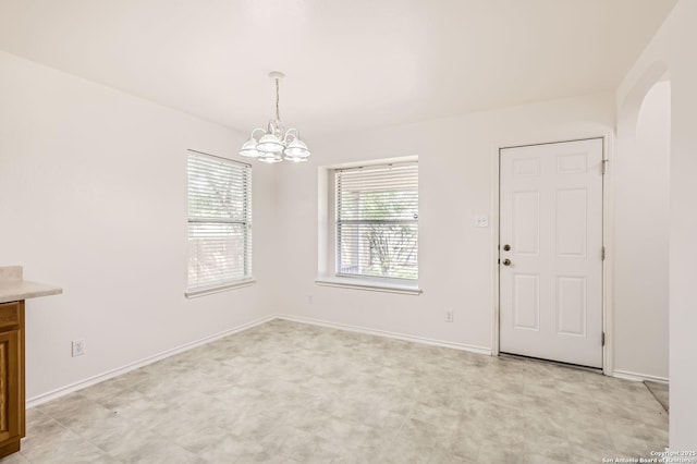 9215 Granberry, Universal City, TX 78148 - unfurnished dining area featuring a chandelier, arched walkways, baseboards, and light floors