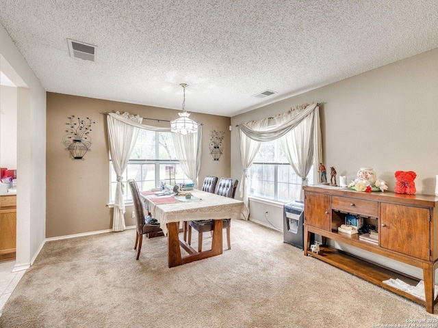 9427 Wildstone, San Antonio, TX 78254 - dining area with a chandelier, light colored carpet, a textured ceiling, and baseboards