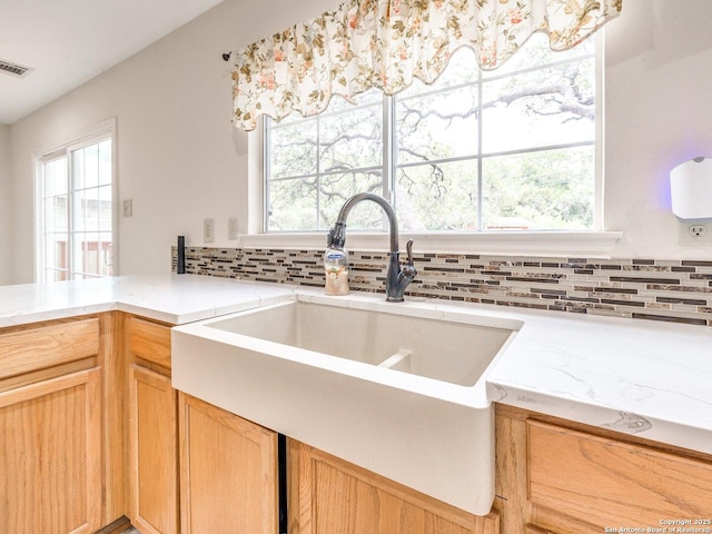 9427 Wildstone, San Antonio, TX 78254 - kitchen featuring a sink, decorative backsplash, and light stone countertops