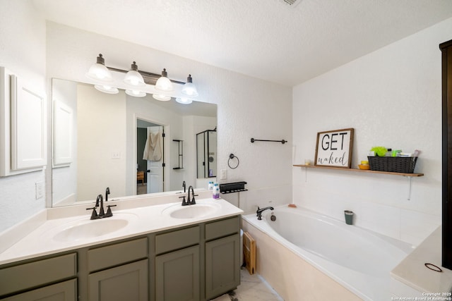 10228 Ancient Anchor, San Antonio, TX 78245 - full bathroom with double vanity, a garden tub, a shower stall, and a textured ceiling