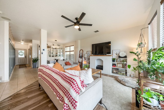 10228 Ancient Anchor, San Antonio, TX 78245 - living area with ceiling fan, plenty of natural light, wood finished floors, and a fireplace